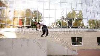 年轻的肌肉男正跳过楼梯的栏杆表演特技. 特技人，跑酷，自由的概念
